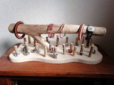 a collection of rings and necklaces on a wooden table next to a white wall