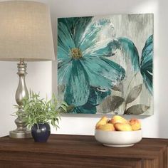 a bowl of fruit sitting on top of a wooden dresser next to a lamp and painting