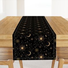 a long table with a black and gold design on it, along with two wooden chairs