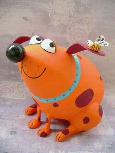 an orange dog statue with a bee on its nose