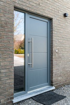 a modern steel door in front of a brick building