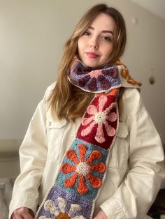 a woman wearing a crocheted scarf with flowers on it