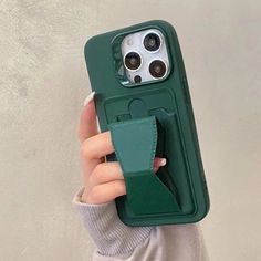 a woman holding up a green phone case with a camera attached to the back of it