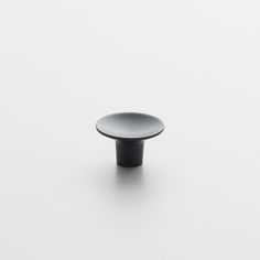 a black and white plate sitting on top of a white countertop next to a wall