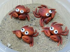 four plastic crabs with googly eyes in the sand