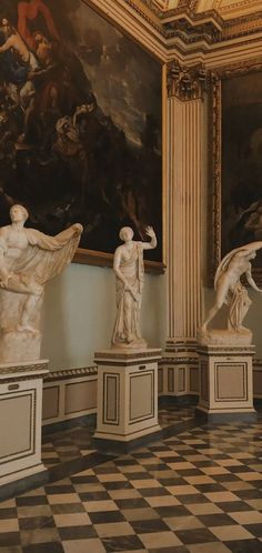 four marble statues in the middle of a checkered floored room with paintings on the walls