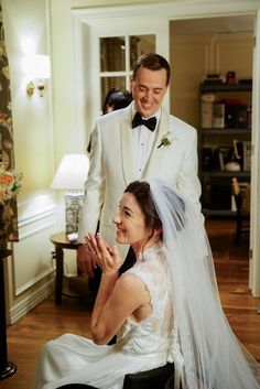 a man in a tuxedo standing next to a woman in a wedding dress