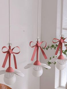 three pink and white lights hanging from a ceiling