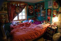 a bedroom with posters on the wall and a bed in it, next to a window