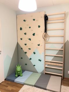 a child's bedroom with climbing wall and play area, including a toy green monster