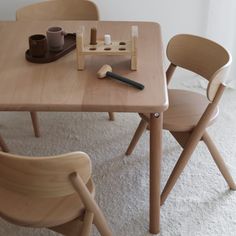 a wooden table with two chairs next to each other and some cups on top of it