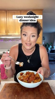 a woman sitting at a table with a bowl of food in front of her