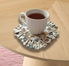 a cup of tea sits on top of a table with a cloth napkin around it