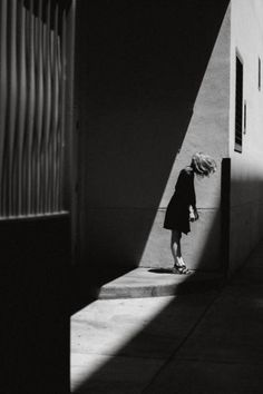 black and white photograph of a woman walking down the street