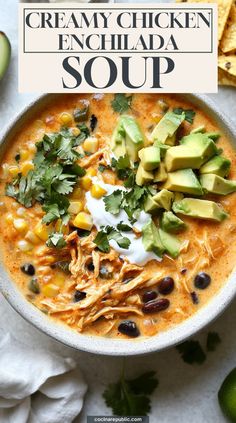 creamy chicken enchilada soup in a white bowl with avocado and sour cream