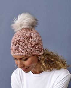 a woman wearing a knitted hat with a white pom - pom