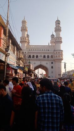 many people are standing in front of a white building