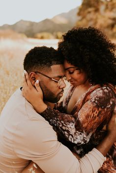 a man and woman embracing each other in a field