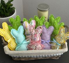 a basket filled with lots of stuffed animals next to a candle and potted plant