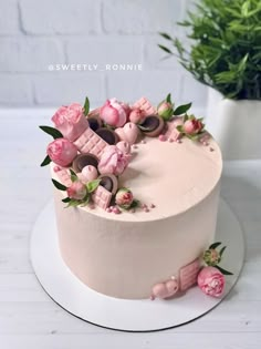 a white cake with pink frosting and flowers on top