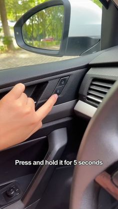 a hand on the steering wheel of a car with trees in the background and text that reads press and hold it for 5 seconds