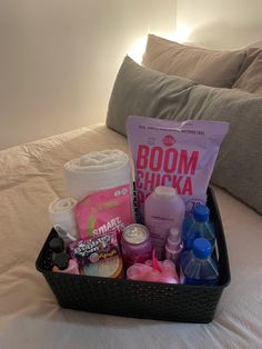 a black basket filled with personal care items on top of a white bedspread