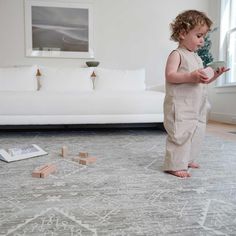 a toddler standing on the floor playing with blocks