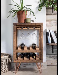 a wooden shelf with wine glasses on it and a potted plant in the corner