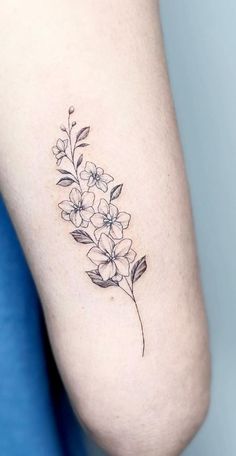 a small flower tattoo on the right arm and leg, it is done in black ink