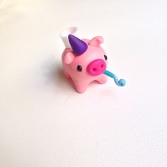 a pink toy pig with a horn on it's head sitting on a white surface