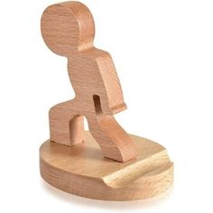 a wooden toy figure sitting on top of a white surface with no one around it