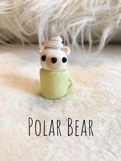 there is a small toy bear with a hat on it's head and the words polar bear above it