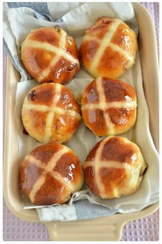 four hot cross buns in a baking dish