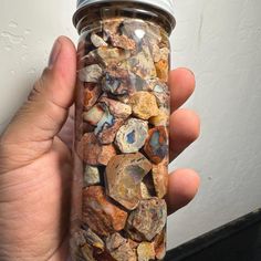 a person holding a jar filled with rocks