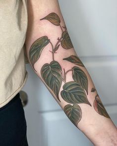 a woman's arm with leaves on it