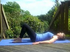 a woman is laying on her stomach while doing an exercise with a blue yoga mat