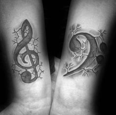 two people with tattoos on their arms and one has a musical note in the middle