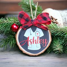 a christmas ornament with a red bow on it sitting on top of a tree