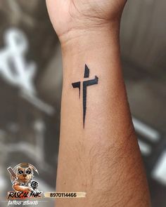 a cross tattoo on the wrist