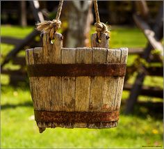 an old wooden bucket hanging from a rope