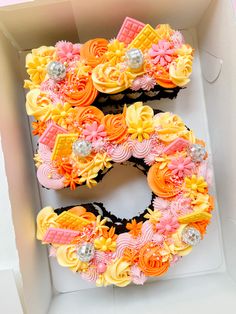 the letter e is made out of cupcakes and decorated with fondant flowers