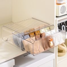 an organized drawer is shown with folded towels and other items in the bins on the shelf