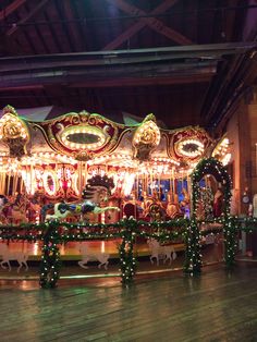 a merry go round with lights and decorations on it's sides in a building