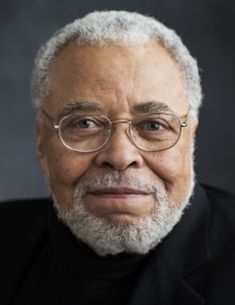 an older man wearing glasses and a black shirt with a white beard is looking at the camera