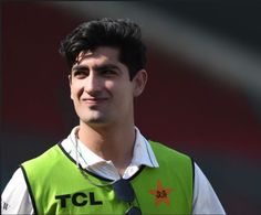 a young man wearing a green vest and tie