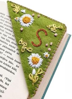 an open book with embroidered flowers on it