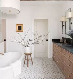 a bathroom with a large white tub and wooden cabinets