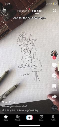 someone is drawing flowers on paper with their cell phone