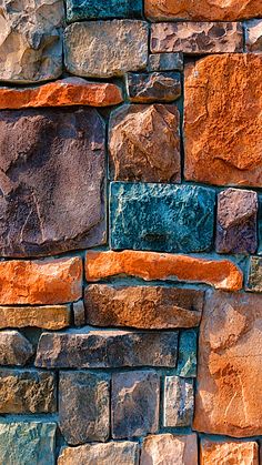 an orange and blue brick wall with some brown rocks