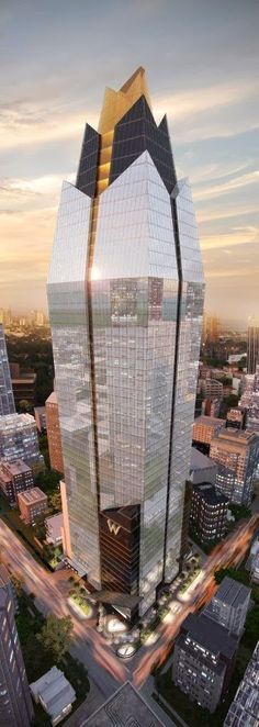 an aerial view of a large skyscraper with many windows in the center and cars on the street below